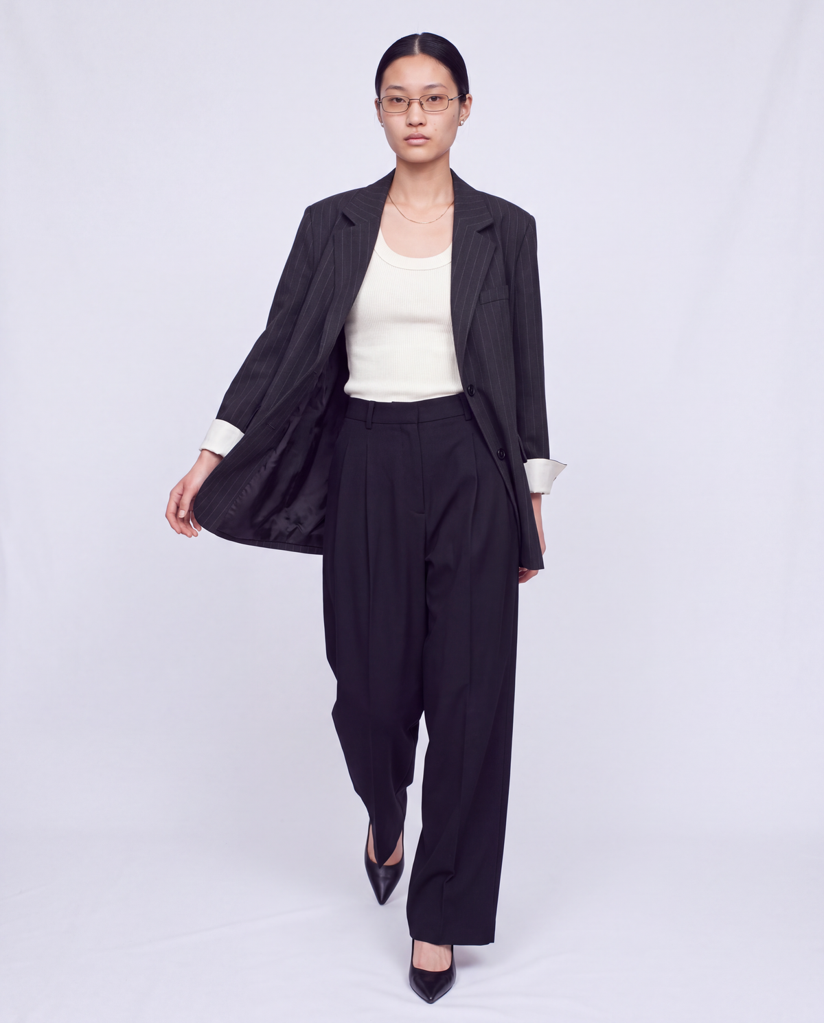 Model wearing the Charcoal Pinstripe Blazer with a white top and black trousers