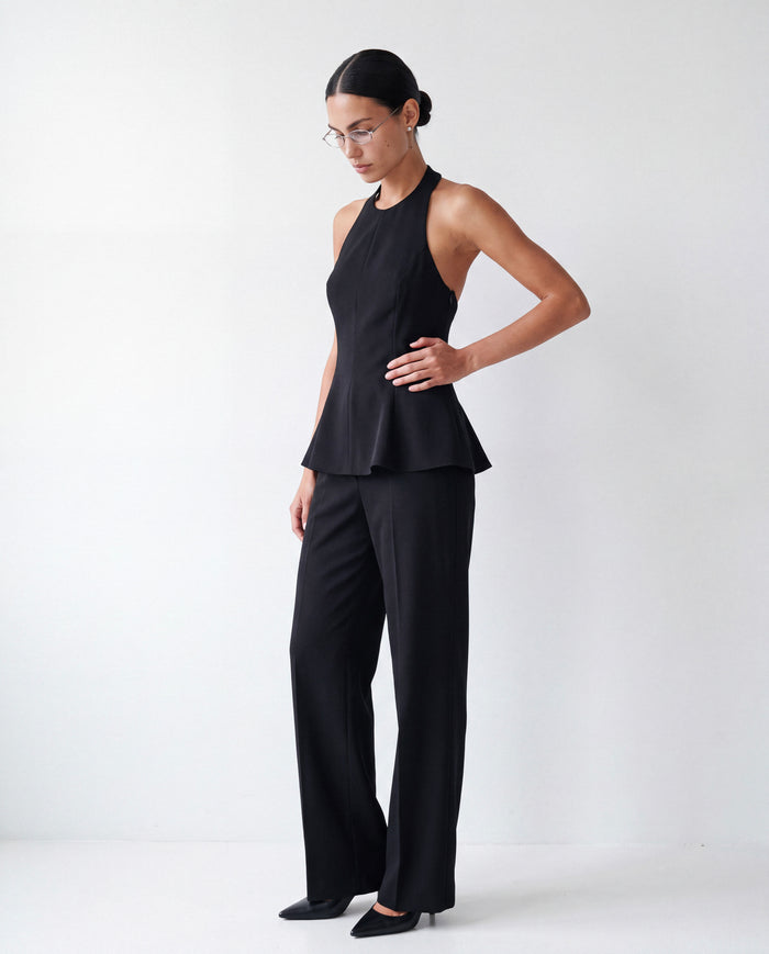 Halterneck Peplum Top in black worn by model, front view