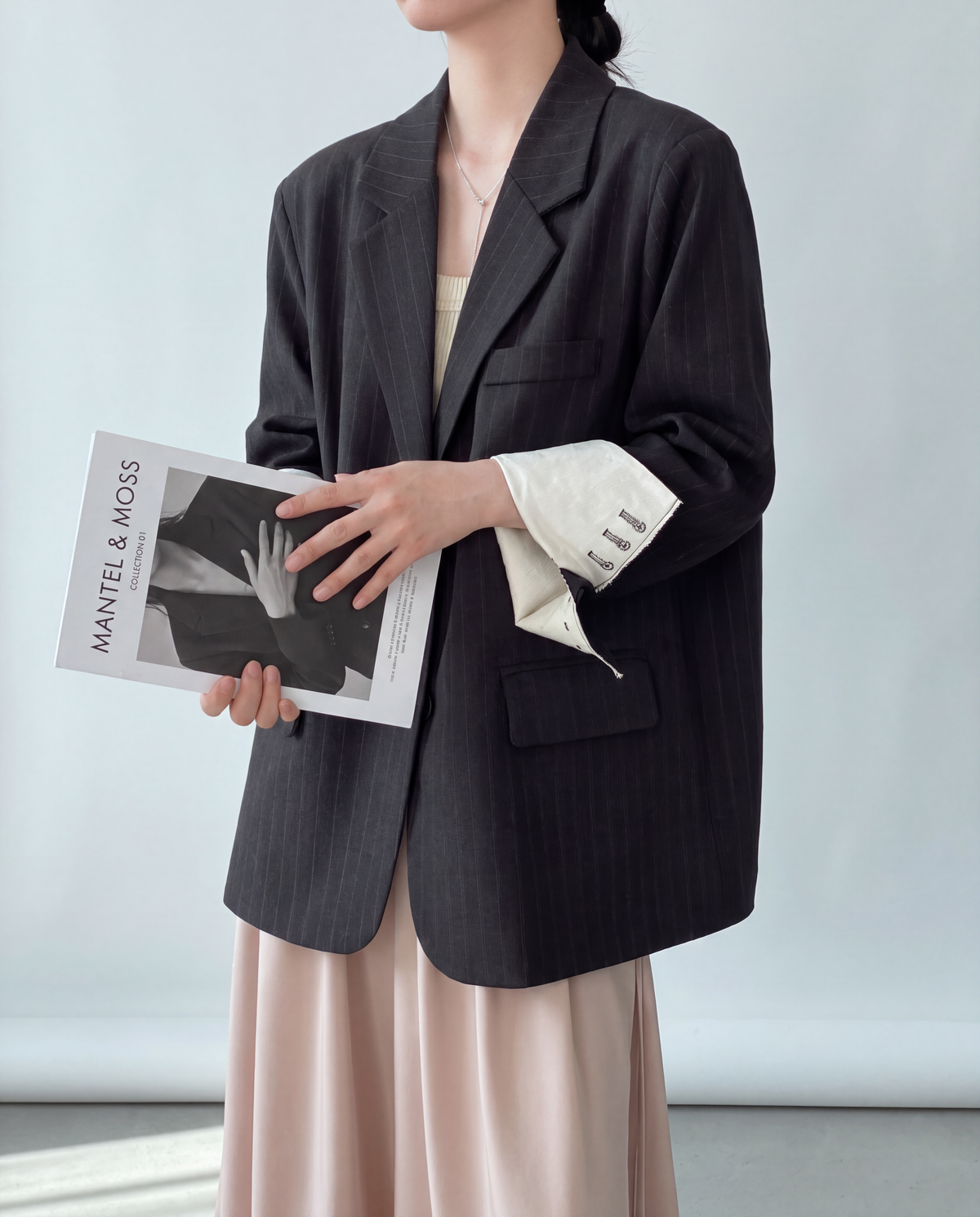 Charcoal Pinstripe Blazer worn by model holding a magazine